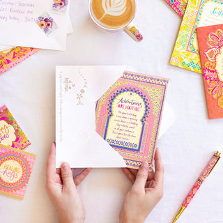Intrinsic ‘Adventures are waiting' birthday themed greeting card with envelope. Unique colourful birthday card with gold foil and inspirational quote on cover by Adele Basheer. Greeting card for someones birthday, card for someone going away on their birthday, birthday holiday card.
