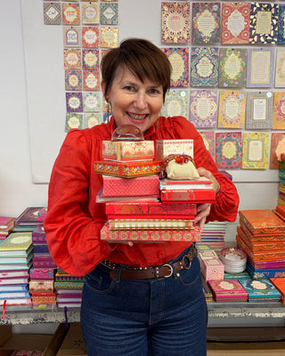 Adèle Basheer with a Red Lovers Mystery Bundle from the Intrinsic Archive Sale, featuring vintage gems, display samples, and end-of-line pieces from past journals, stationery, travel, ceramic, jewellery, accessories or homewares collections.