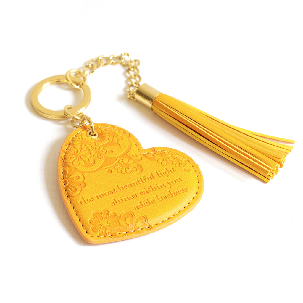 Inspirational vegan leather heart shaped sunshine yellow keychain with gold chain and marigold yellow tassel. Designed in South Australia. Motivational quote by Adèle Basheer.