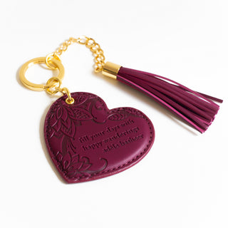 Inspirational vegan leather heart shaped plum purple merlot keychain with gold chain and dark red tassel. Designed in South Australia. Motivational quote by Adèle Basheer.