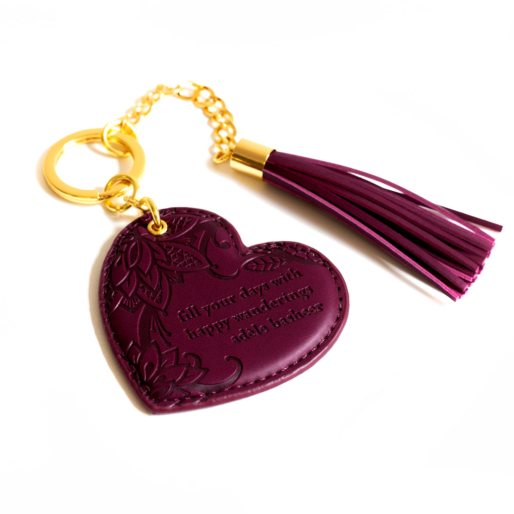 Inspirational vegan leather heart shaped plum purple merlot keychain with gold chain and dark red tassel. Designed in South Australia. Motivational quote by Adèle Basheer.