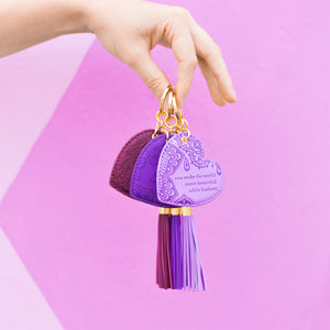 Bright coloured dark purple key holder with vegan leather floral pattern and violet purple tassel. Featuring heartfelt quote by Adèle Basheer.On the go inspirational gift-boxed violet purple key ring.